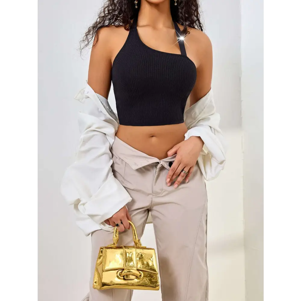 Gold metallic handbag with structured rectangular shape and prominent clasp detail complementing black ribbed solid shoulder vest featuring low cut one shoulder design