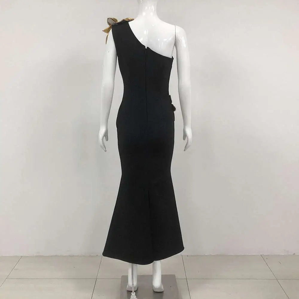 Black satin bandage flower maxi dress with one-shoulder design and gold bow accent at the shoulder