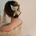 Cream-colored satin female graceful bow grip with gold-toned metal clasp for elegant black satin bow grip shark style