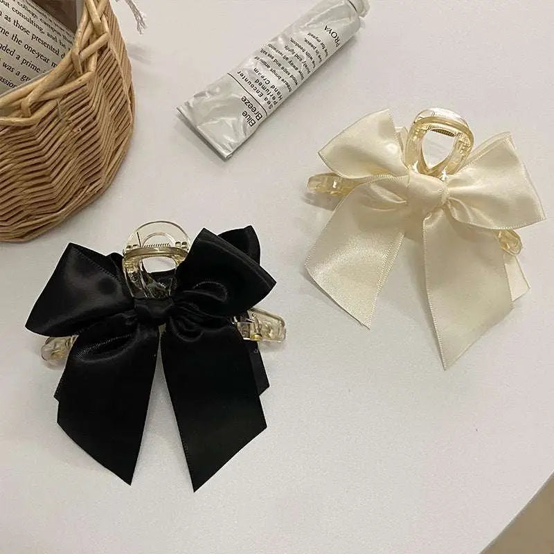 Elegant black satin female graceful bow grip shark clip with a clear acrylic frame for stylish hair hold