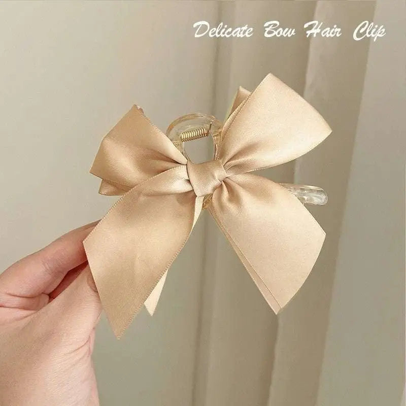 Elegant black satin female graceful bow grip shark clip with a clear acrylic frame for stylish hair hold