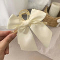 Black satin satin female graceful bow grip shark clip with a delicate cream satin bow on a transparent plastic clip