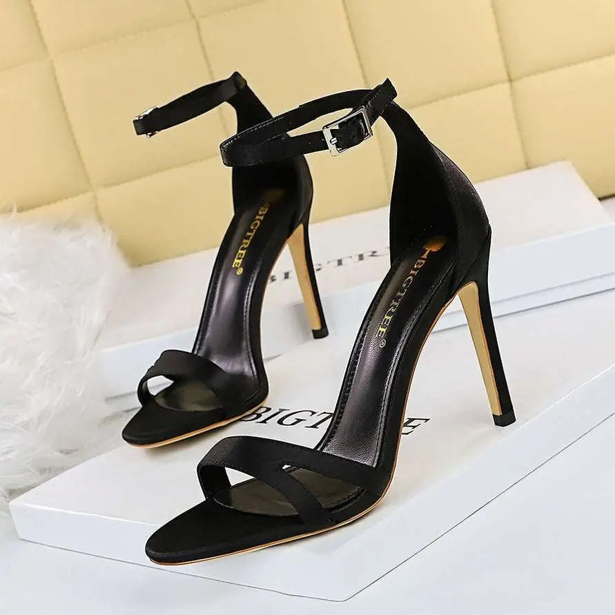 Black satin high heel toe cutout sandals with sleek minimalist design and silver buckle ankle strap