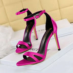 Vibrant fuchsia satin high heel toe cutout sandals with sleek ankle strap and metallic buckle