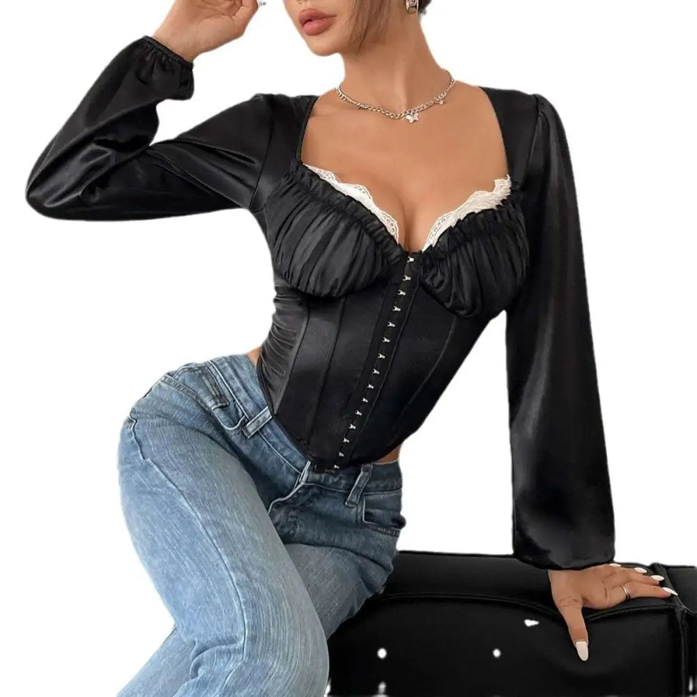 Black satin mesh long-sleeve corset top with patchwork lace chest, white lace trim, and front button closure