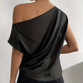Black satin solid color asymmetrical one-shoulder top with draped flowing fabric and color asymmetrical collar