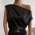 Black satin solid color asymmetrical one-shoulder top with draped fabric and sleek minimalist design
