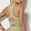 A sage green seamless women’s shockproof running sports bra with racerback design and cutout details