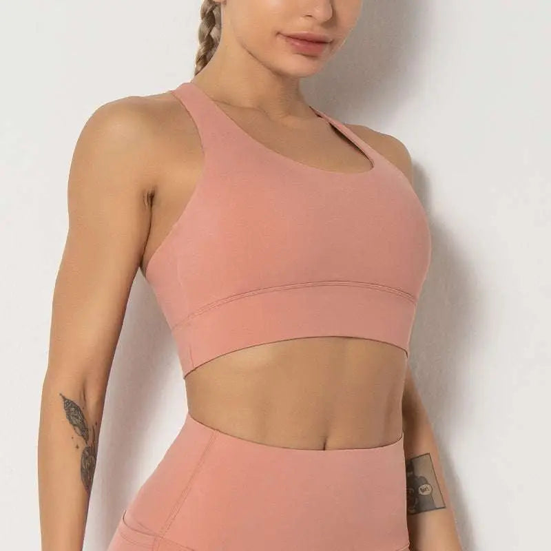 A soft pink seamless women’s shockproof running sports bra with form-fitting design and racerback style