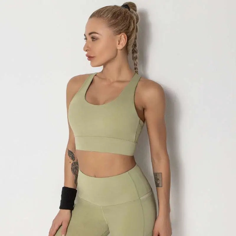 Olive green seamless women’s shockproof running sports bra with racerback design paired with high-waisted leggings