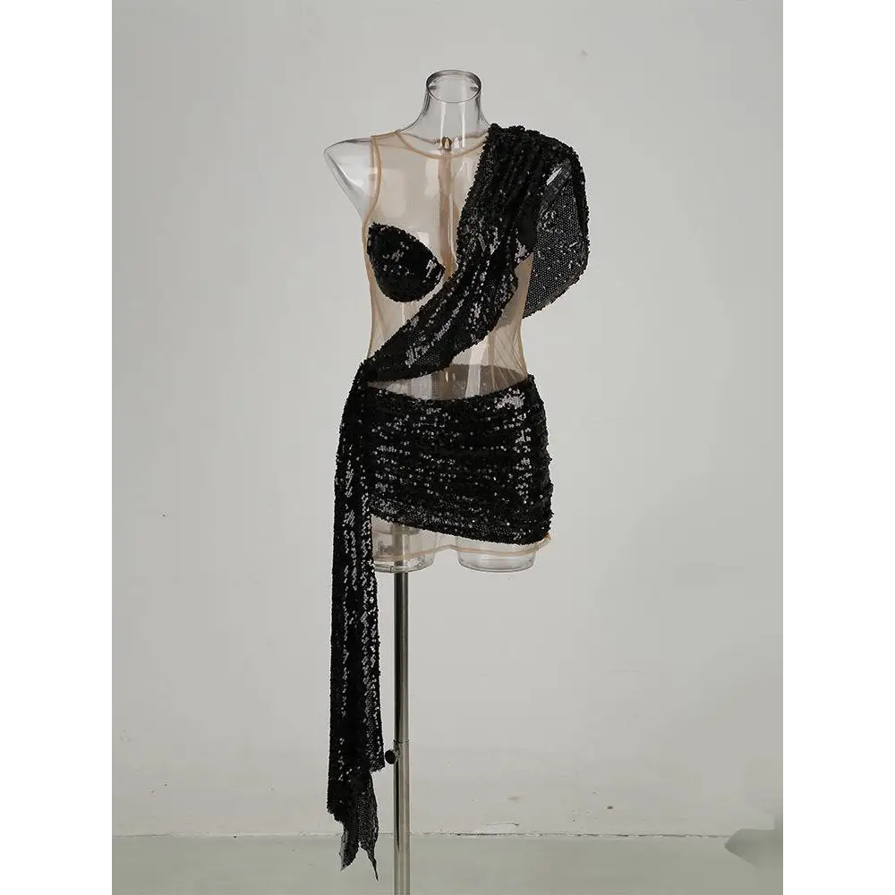 Black sequined elegant one-shoulder mini dress with sheer mesh bodice and draped fabric detail in vibrant emerald green