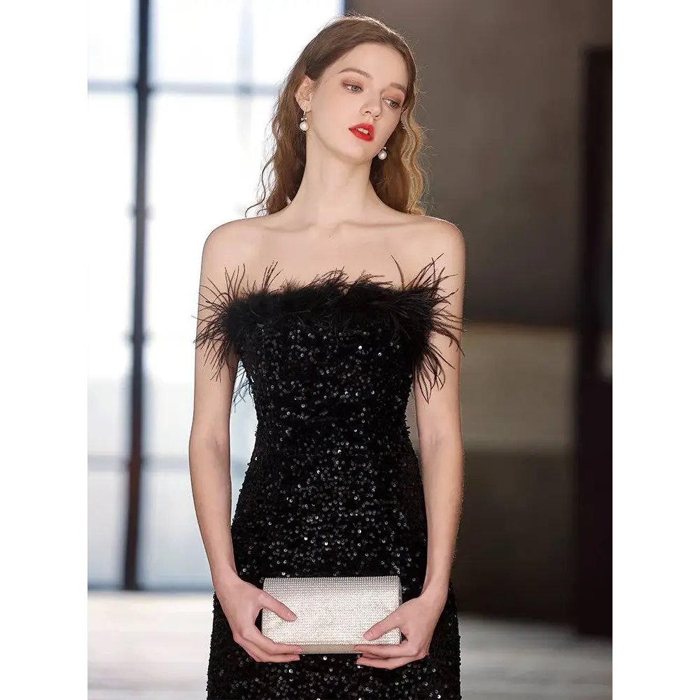 Black sequined feather trim banquet evening dress with strapless design and silver rhinestone clutch accessory