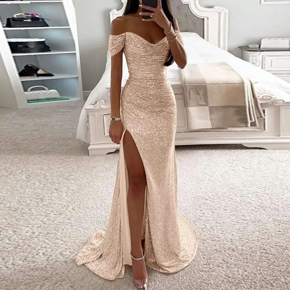 A shimmering rose gold sequined off-the-shoulder gown with high slit and flowing train in a fitted silhouette