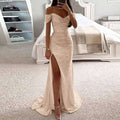 A black sequined off-the-shoulder gown with a shimmering gold high slit and flowing train in a fitted silhouette