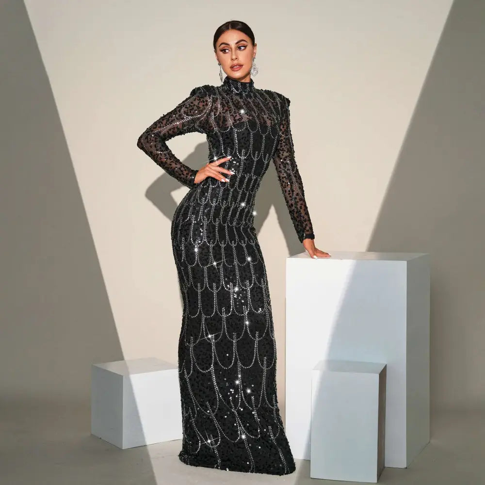 Black sequined long sleeve round neck evening dress with sheer sleeves and silver chain detailing for banquet evening wear