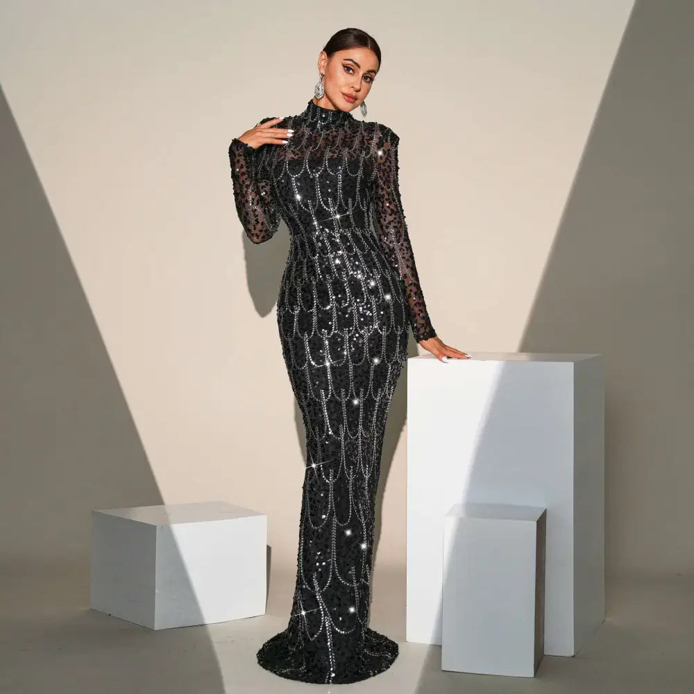 Black sequined long sleeve round neck evening dress with sheer sleeves and silver chain detailing for banquet evening wear