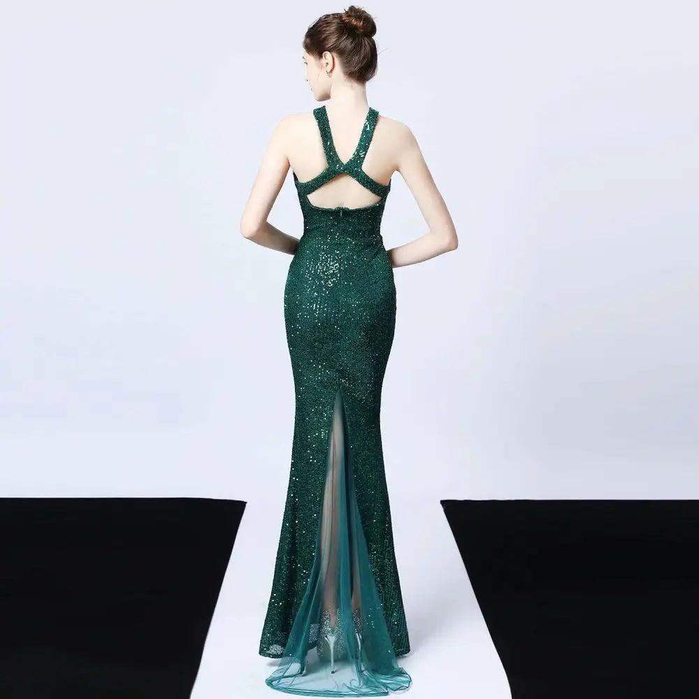 Emerald green sequined mermaid dress with backless design and sheer panel seen from back side