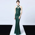 Emerald green sequined mermaid dress with halter neckline and crisscross straps in long skirt length