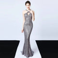A shimmering silver sequined mermaid dress with halter neckline and cut-out detail featuring long skirt length