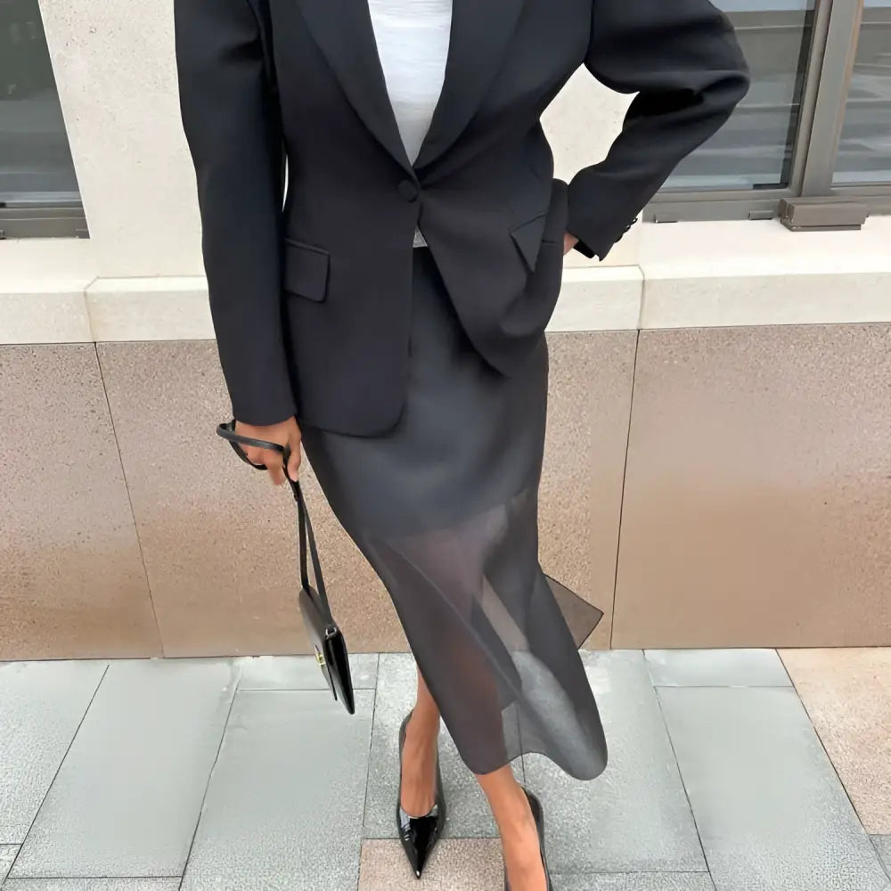 Black sheer high waist slit sheath skirt paired with solid black blazer and matching high heels in a formal look