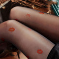 Translucent black sheer snagging resistant sock leggings with vibrant orange lipstick print and lettering design