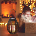 Black solar retro patio woven rattan lantern with warm glowing light and solar panel on top