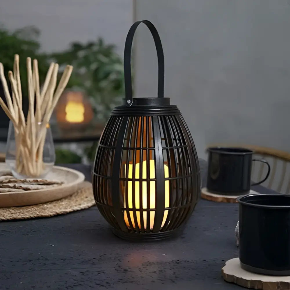 Black solar retro patio woven rattan lantern with warm glowing light inside for outdoor decoration