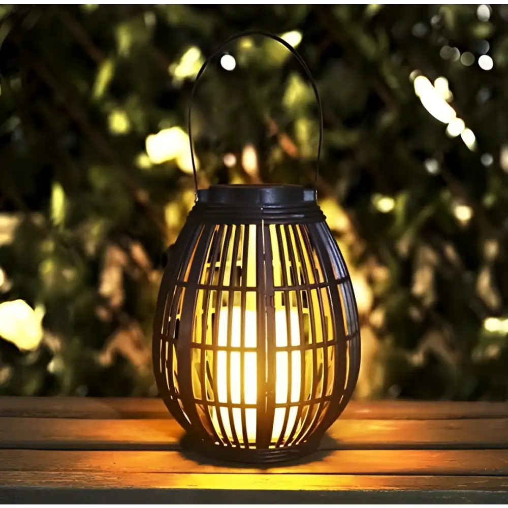 Black wrought iron lantern with warm glowing light inside solar retro patio woven rattan lantern design