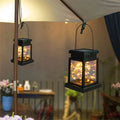 Black solar waterproof garden hanging lights with warm glowing fairy lights inside for outdoor decoration
