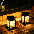 Black solar waterproof garden hanging lights featuring clear glass panels with warm white string lights inside