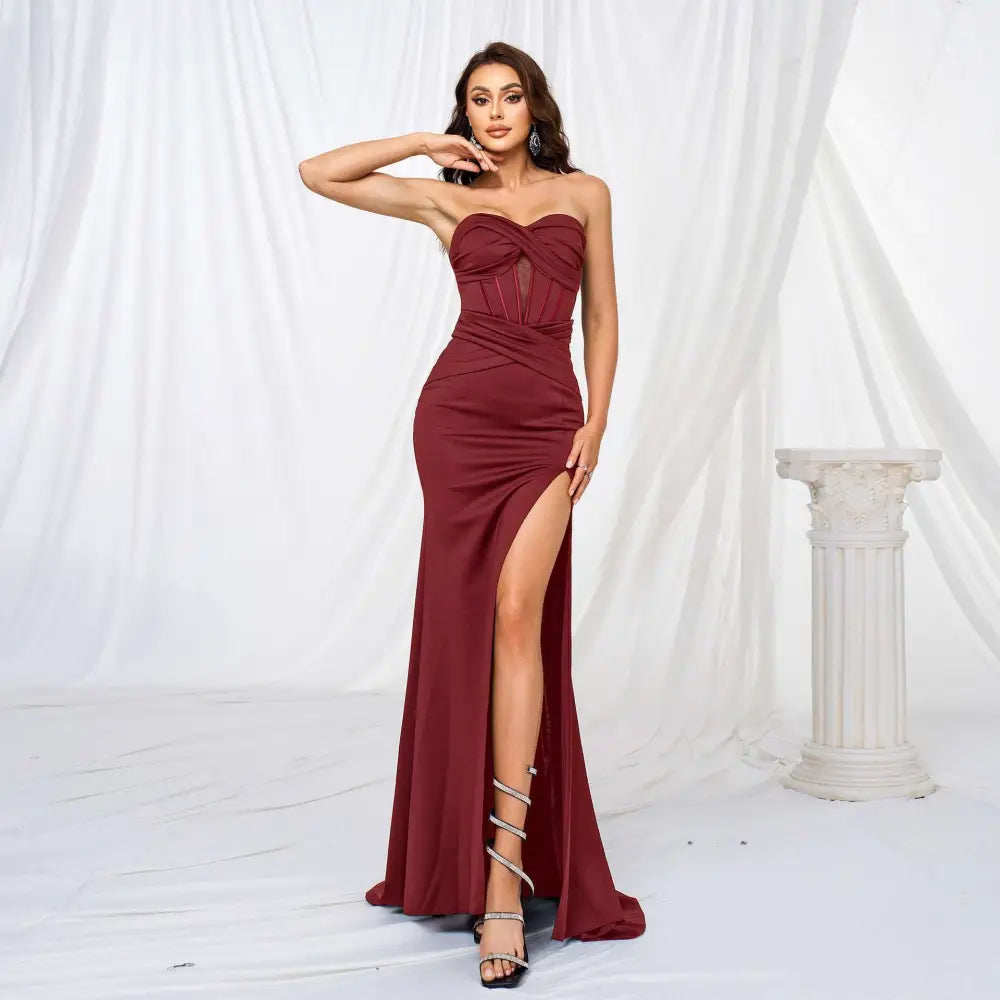 Elegant deep burgundy form-fitting strapless gown with twisted bodice and high slit hem evening dress