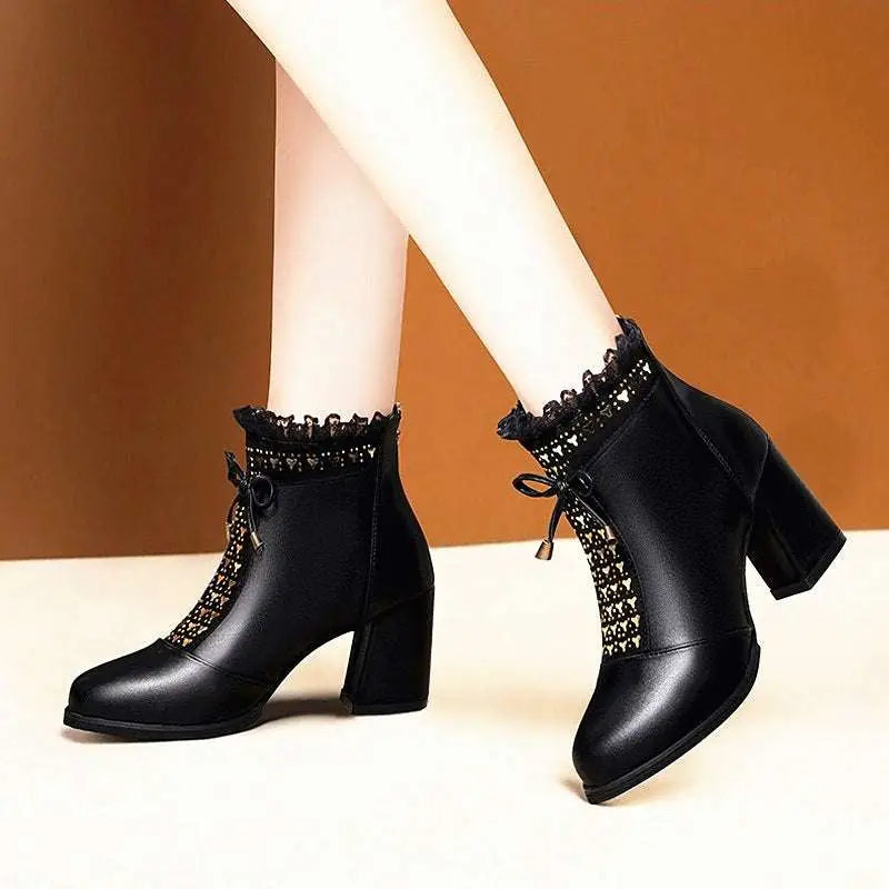 Black studded chunky heel martin boots in black leather ankle style with lace trim and decorative zipper details