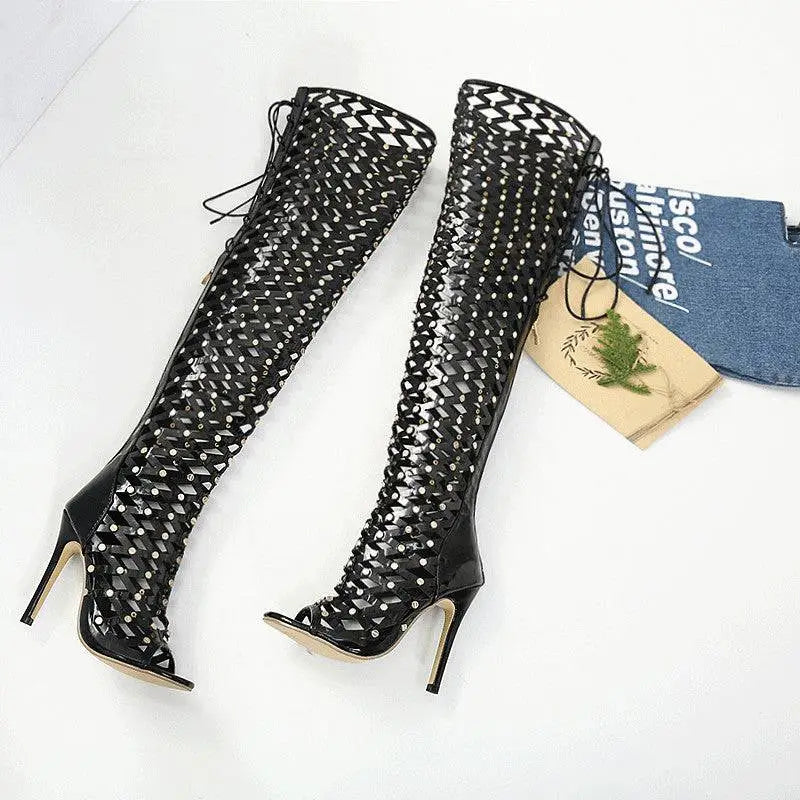 Black studded lace up heel sandal boots featuring over-the-knee design with woven mesh and silver studs