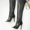 Black studded lace up high heel sandal boots in patent leather featuring over-the-knee geometric cutout design