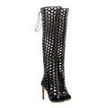 Black studded lace up heel sandal boots featuring a glossy lattice design and silver studs over-the-knee style