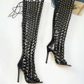 Black studded lace over-the-knee heel sandal boots with glossy finish and intricate lattice design featuring silver studs