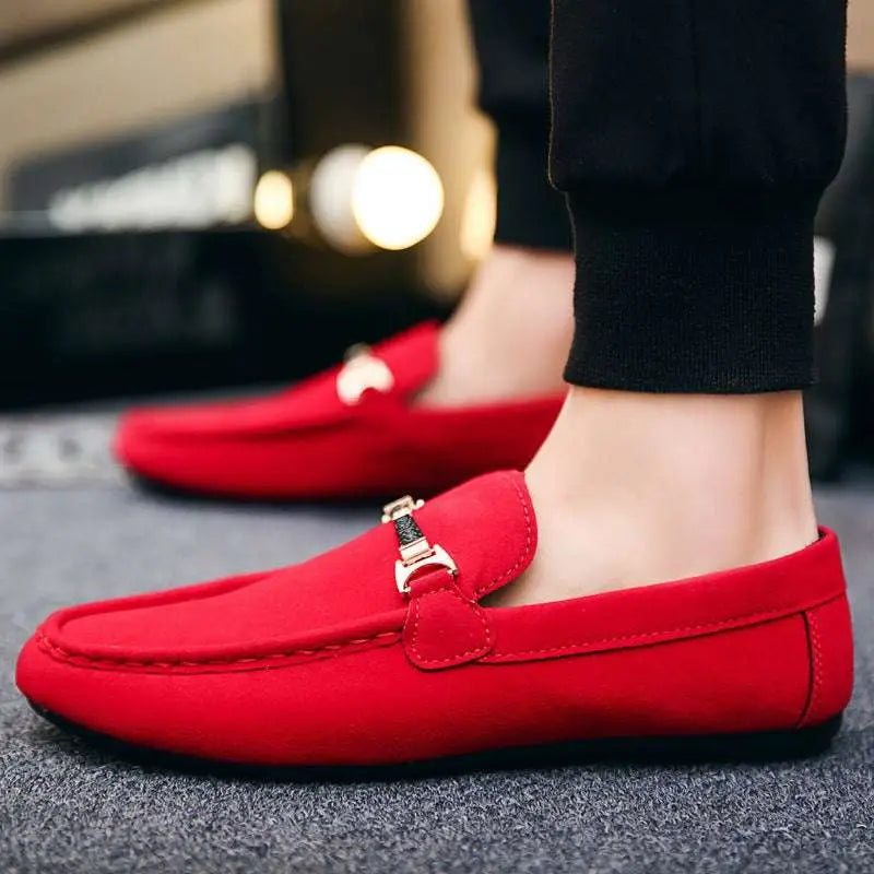 Vibrant red suede loafers with a gold-tone horsebit buckle accent and flat heel for casual wear