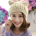 A cream-colored knitted cat ear beanie with soft plush ears in a black textured cute style
