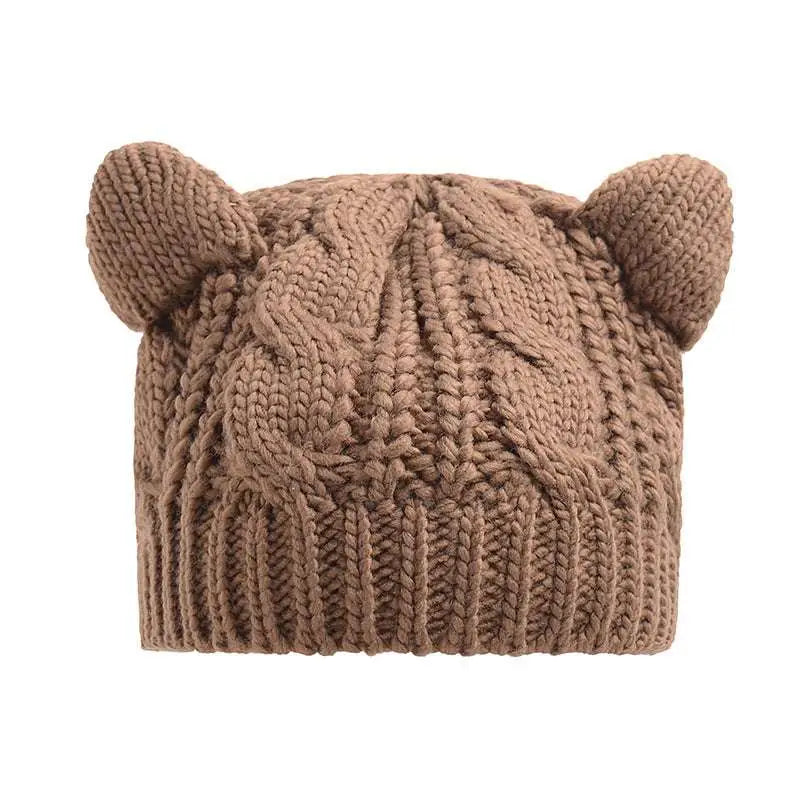 A cozy beige knitted cat ear beanie featuring a textured cable knit pattern and soft rounded ear-like protrusions