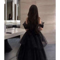 Black velvet and tulle light luxury evening dress with off-the-shoulder sleeves and a layered sparkly skirt