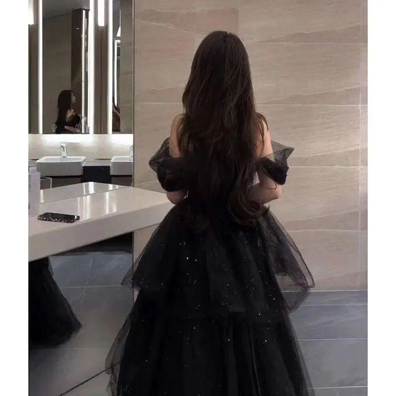 Black velvet and tulle light luxury evening dress with off-the-shoulder sleeves and a layered sparkly skirt
