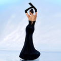 A sleek black velvet strapless mermaid gown with a corseted back and chest wrap hip design with long gloves