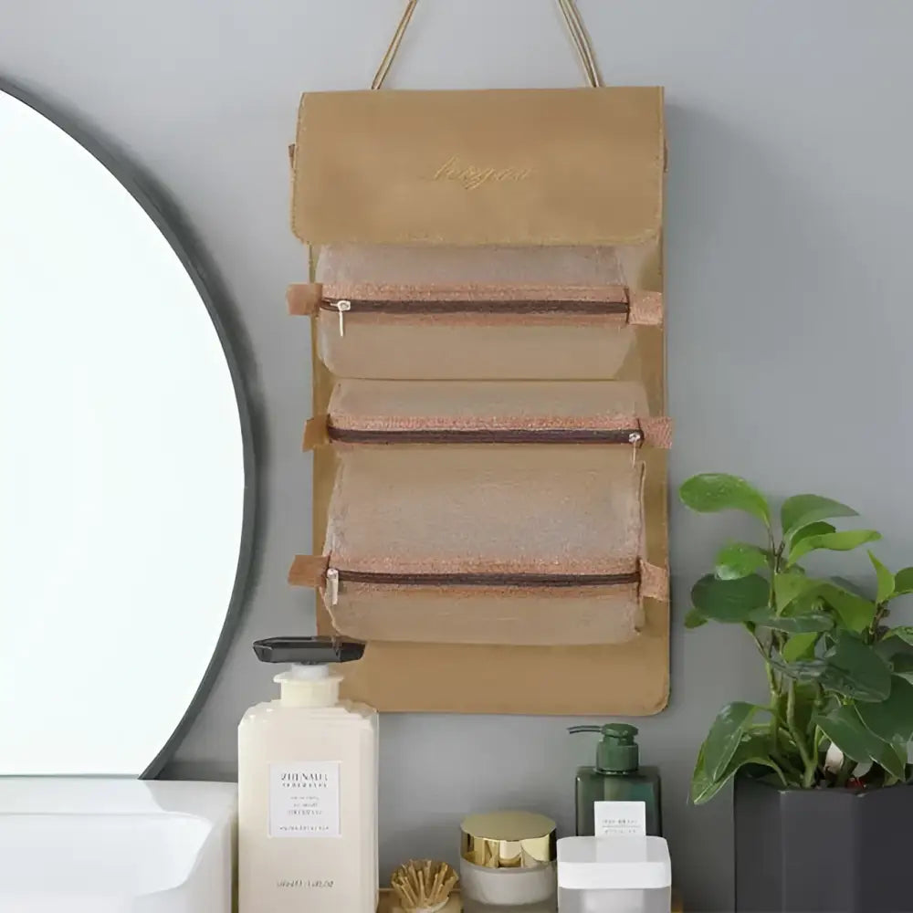 Beige canvas wall mounted organizer with three zippered compartments and gold tone hardware for portable women makeup use