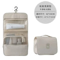 Beige canvas toiletry bag with mesh compartments and hanging hook for black wall mounted portable women makeup use