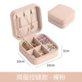 A blush pink compact zippered jewelry box with soft fabric interior and compartments for a black wall mounted portable women makeup bag