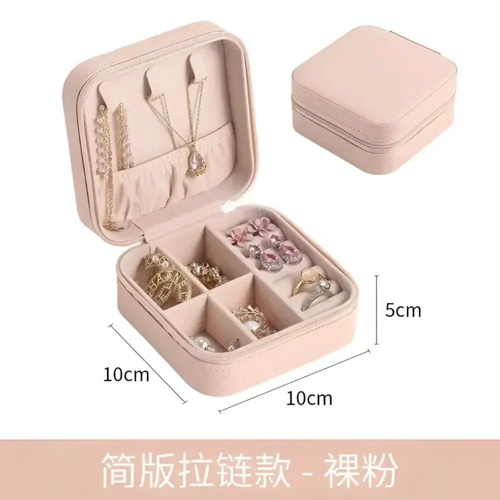 A blush pink compact zippered jewelry box with soft fabric interior and compartments for a black wall mounted portable women makeup bag