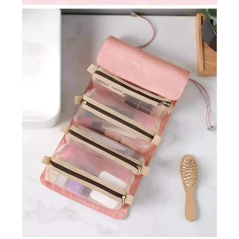 Pink roll-up travel organizer with clear zippered compartments and beige trim for portable women makeup storage