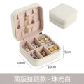 A compact cream-colored faux leather jewelry box with soft pink lining and compartments, ideal for black wall mounted portable women makeup storage