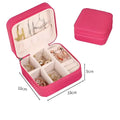 Pink rectangular jewelry box with quilted exterior and white interior compartments for black wall mounted portable women makeup bag