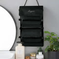 Black wall mounted portable women makeup bag with five zippered compartments and embroidered brand name